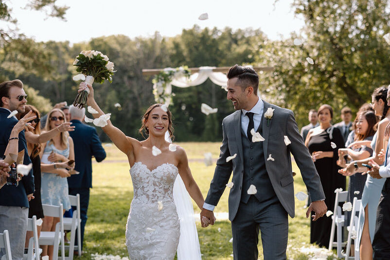 Newly married couple walking down the aisle after an outdoor ceremony at Fermanagh Farms